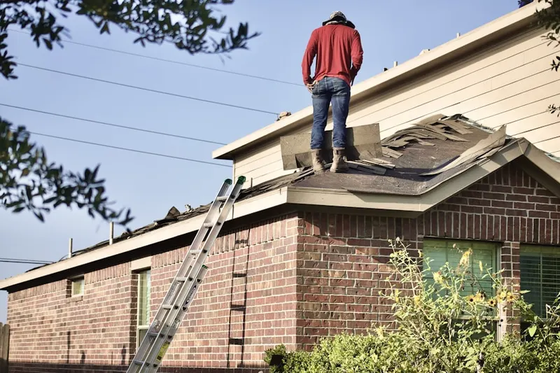 Professional roofer working on a residential roof in Town Brook